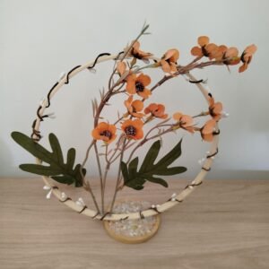Centre de table sur cercle bois avec fleurs orangées